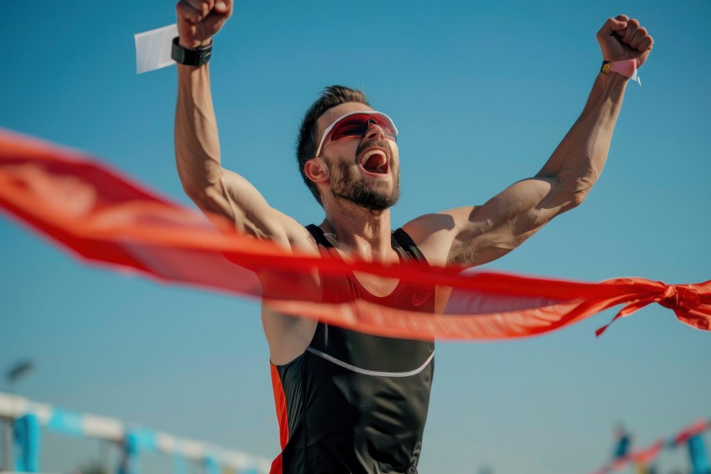An athlete, man, runner, arrives at a finish line. Concepts of success, win, and achievement