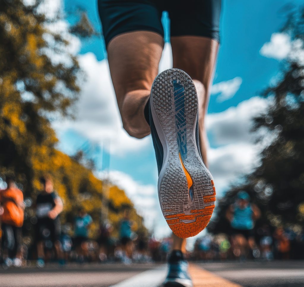 Athlete running on the road with other runners during marathon