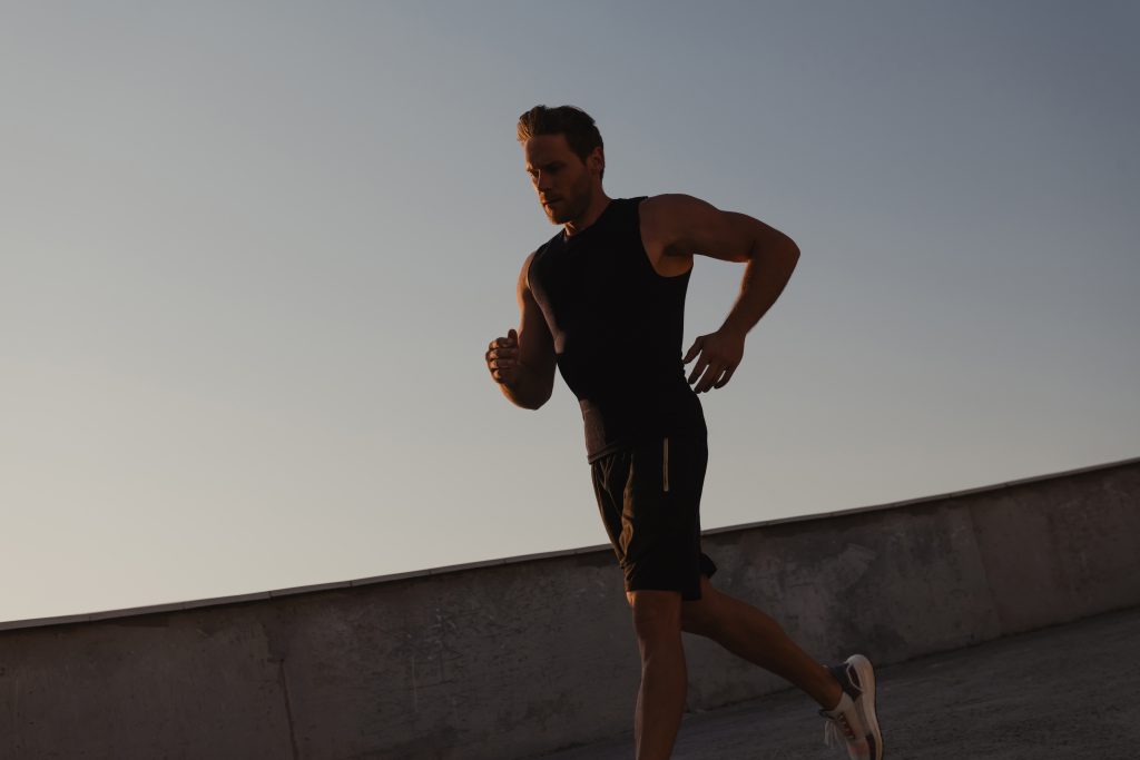 Athletic young man in sports clothing enjoying morning jog outdoors