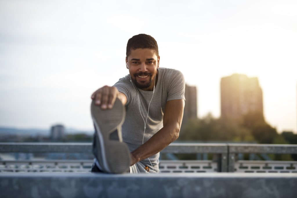 An attractive athlete stretching legs and preparing for running training.