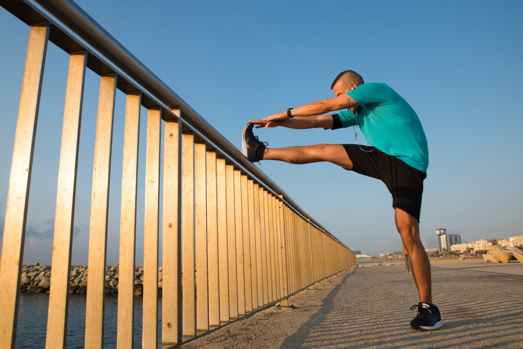 Energetic male athlete stretching on bridge