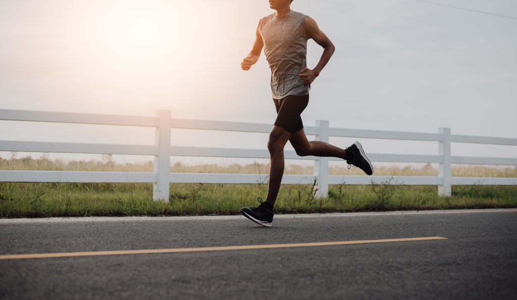 The man with runner on the street be running for exercise.