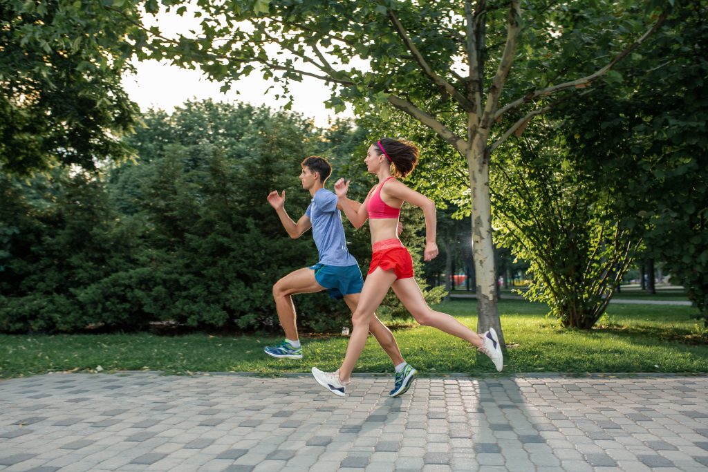 Portrait of cheerful caucasian couple running outdoors
