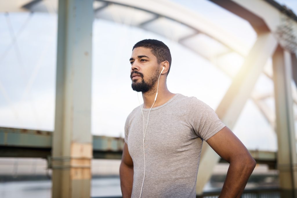 Portrait of handsome sportsman with earphones preparing for training.