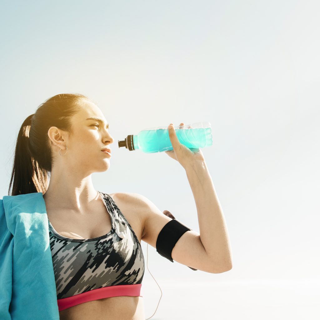 sporty-woman-drinking-sky-background