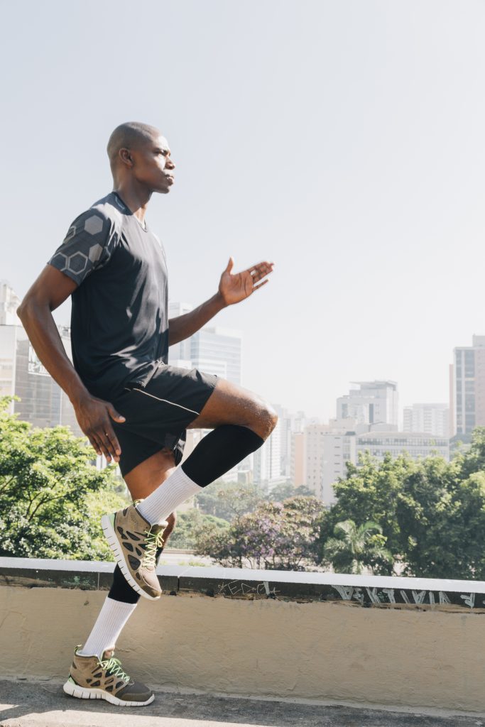young-fitness-woman-runner-warming-up-before-running-rooftop